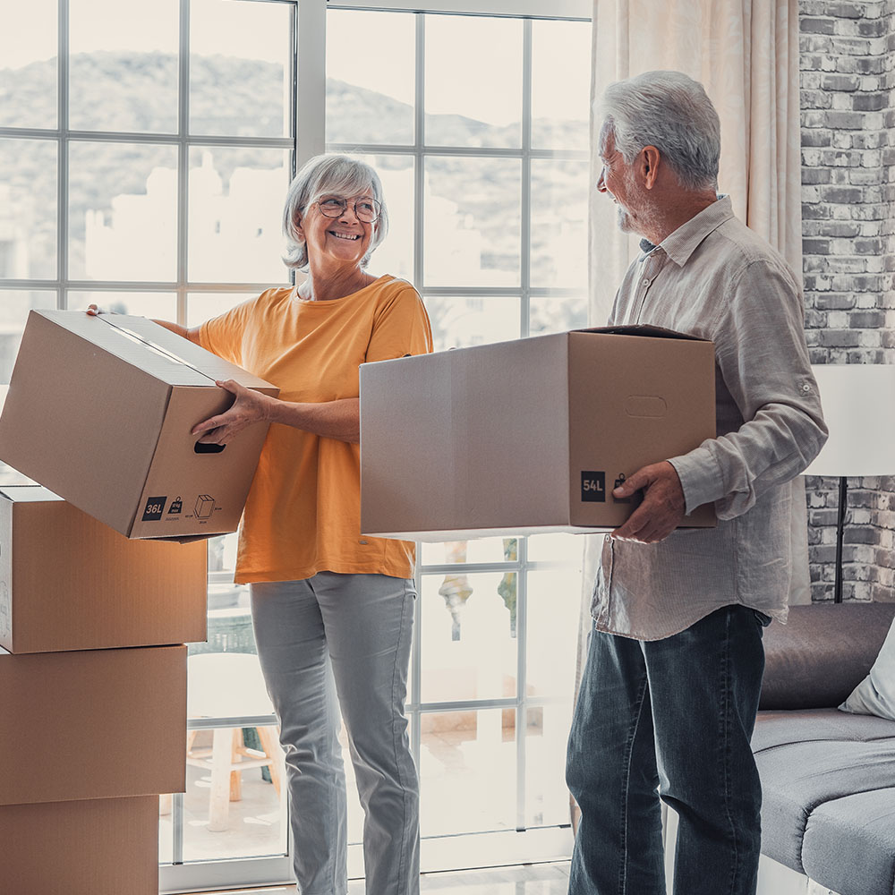 An older couple with moving boxes moving homes